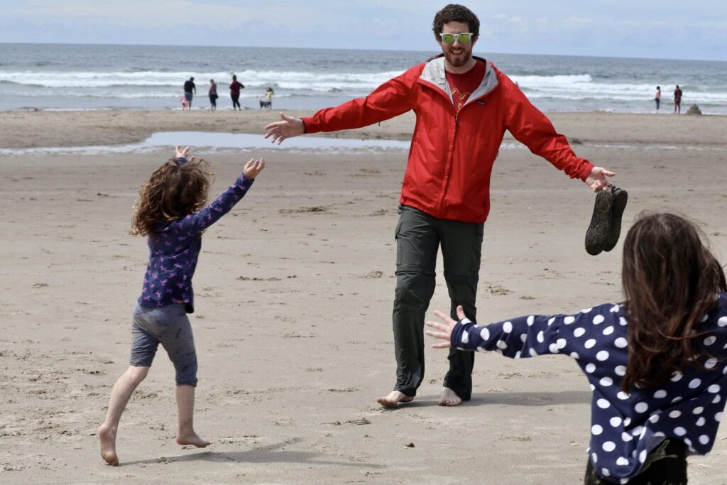 A man stretches out his arms to welcome his children.